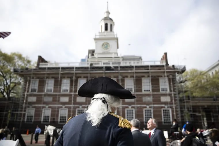 Dean Malissa, portraying George Washington stands in view of Independence Hall.