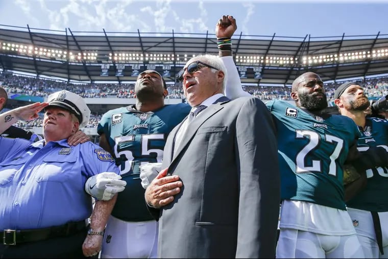 Malcolm Jenkins (right) raising his first as a form of protest during the national anthem before a September game against the Giants alongside Eagles owner Jeffrey Lurie and defensive end Brandon Graham.