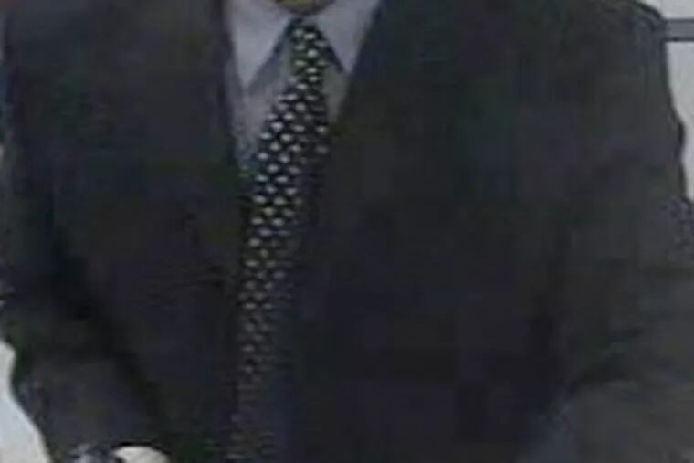 The bank robbery suspect is described by police and the FBI as an African American man in his mid to late 30s, 6-foot-3 or 6-foot-4 tall, wearing large sunglasses, a dark dress suit with a light-blue dress shirt and print tie, a dark knit ski cap, light colored gloves and a white painter's mask with blue strap.