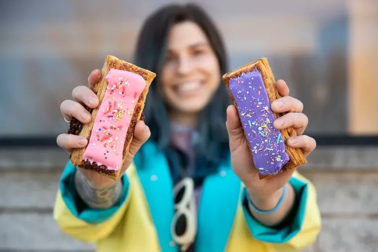 Erika Burke posed for a portrait while holding strawberry rhubarb and blackberry pop-tarts outside of Essen Bakery in Philadelphia, Pa. on Sunday, March 21, 2021. Burke makes flaky af pop-tarts.