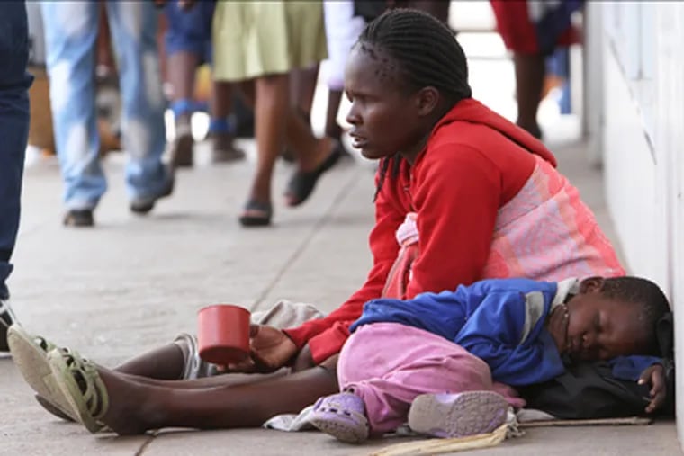 A blind woman begs for money while her child sleeps next to her on the streets of Harare, Zimbabwe, Thursday, Dec. 5, 2013. According to the latest independent surveys in Zimbabwe the gap between the rich and poor continues to grow. The  recent elections in the country have done little to deal with the challenges facing a nation trying to recover from an economic meltdown and the ravages of hyperinflation. (AP Photo/Tsvangirayi Mukwazhi)