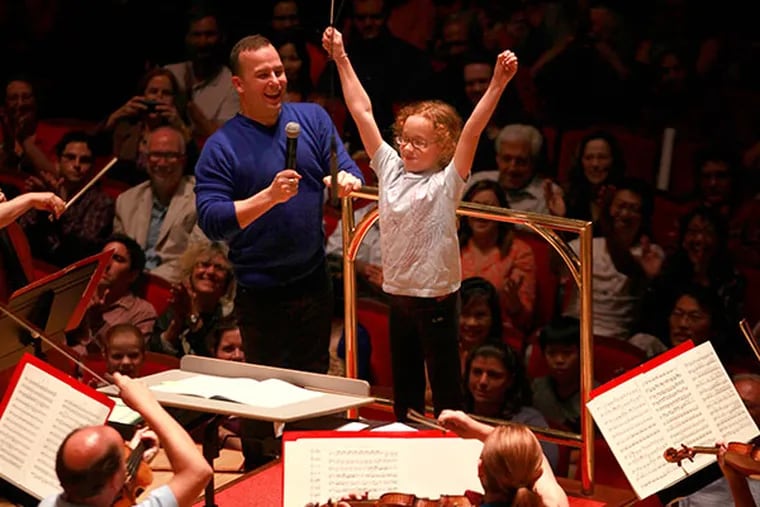 Guest conductor Madeline Church, 9, Philadelphia with music conductor Yannick Nezet-Seguin's help finishes the William Tell Overature during a pop up concert at the Kimmel Center after the Philadelphia Orchestra returned from a strike at Carnegie Hall October 2, 2013. ( DAVID SWANSON / Staff Photographer )