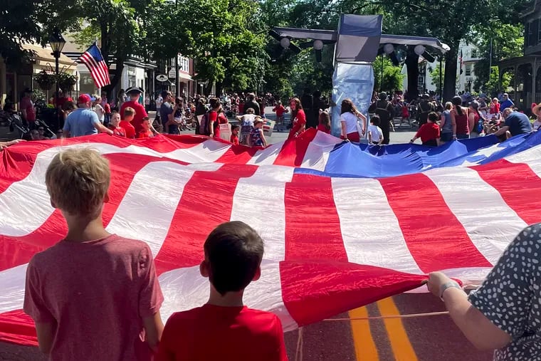 A large American flag and a WWII bomber parade through downtown Haddonfield July 5, 2021 on the Independence Day weekend.