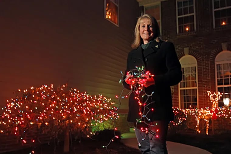 After notification from the Doylestown Station condo association board that her white-lighted reindeer was in violation, resident Judith Wonderly went all out and strung colored lights outside her home. (Michael Bryant / Staff Photographer)