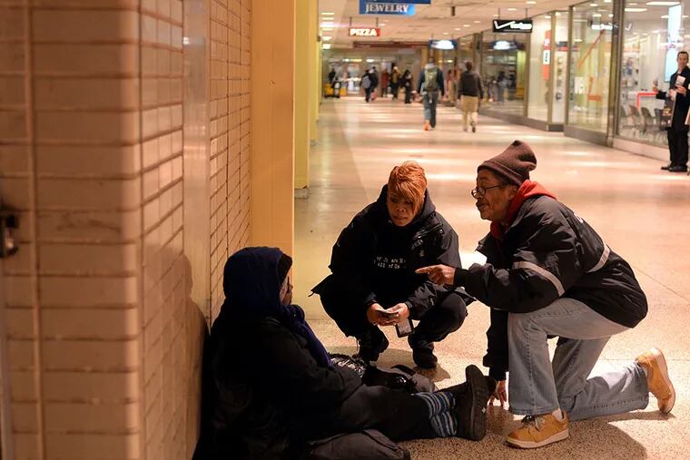 Project HOME outreach members Tanya Baker and Hyacinth King (right) speak with Betty Wilson in the SEPTA concourse in Center City. They persuaded Wilson to go with them to a shelter. TOM GRALISH / Staff Photographer