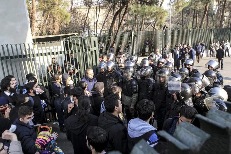 In this photo taken by an individual not employed by the Associated Press and obtained by the AP outside Iran, anti-riot Iranian police prevent university students to join other protesters over Iran weak economy, in Tehran, Iran, Saturday, Dec. 30, 2017. A wave of spontaneous protests over Iran's weak economy swept into Tehran on Saturday, with college students and others chanting against the government just hours after hard-liners held their own rally in support of the Islamic Republic's clerical establishment. (AP Photo)