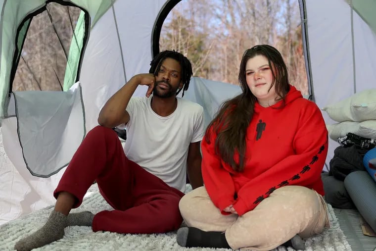 Leland Brown Jr. (left) and Breanna Hubbard in their tent in Lansdale, Pa. They are chronicling their journey of being unhoused on TikTok.