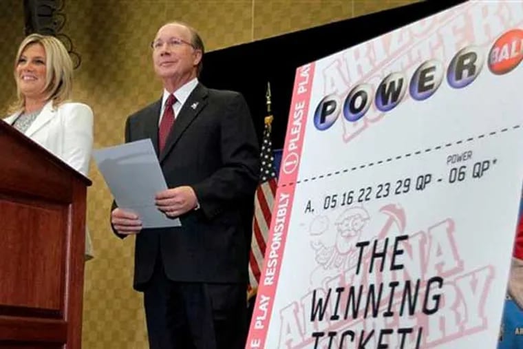 Arizona Lottery Director of Budget, Products and Communications Karen Bach, left, and Arizona Lottery Executive Director Jeff Hatch-Miller stand next to an enlargement of the winning $587.5 Million Powerball ticket, Friday, Dec. 7, 2012 during a news conference in Scottsdale, Ariz. The Lottery held the news conference to announce that the Arizona Lottery Powerball jackpot winning ticket has been claimed by an unidentified Arizona man. The $587.5 million jackpot is the largest in Powerball history and will be shared by co-winners Mark and Cindy Hill from Missouri. (AP Photo/Matt York)