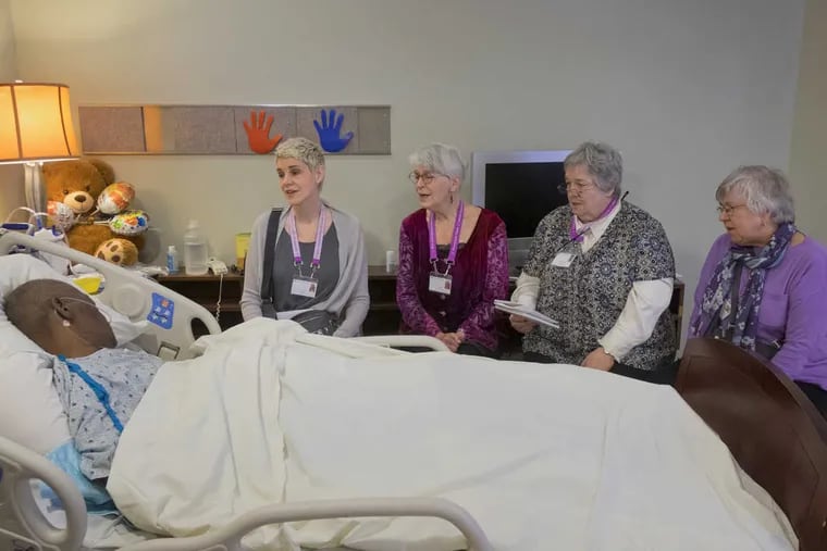 Songs in the key of life: The Threshold Choir sings for patient Charles Seawright Sr.  in Penn Hospice at Rittenhouse. The ensemble visits every Friday to sing for hospice patients.