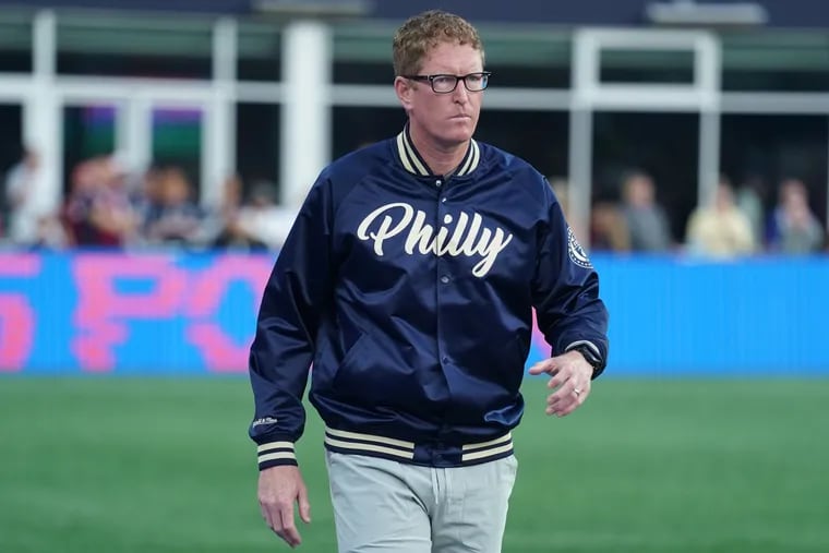 Union manager Jim Curtin on the sideline during Saturday's game at New England, wearing a varsity-style jacket designed by Mitchell & Ness.