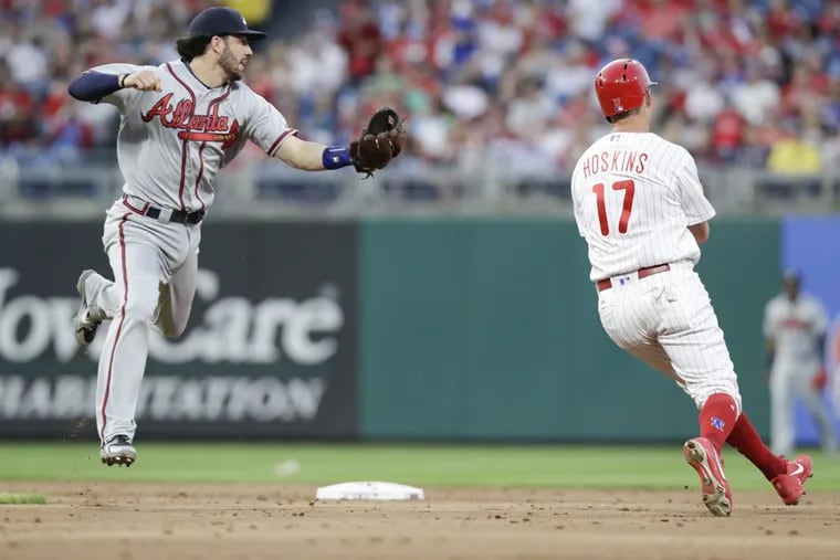 Phillies slugger Rhys Hoskins avoids the tag from Braves shortstop Dansby Swanson during the third inning of the Phillies win over the Braves on Wednesday.