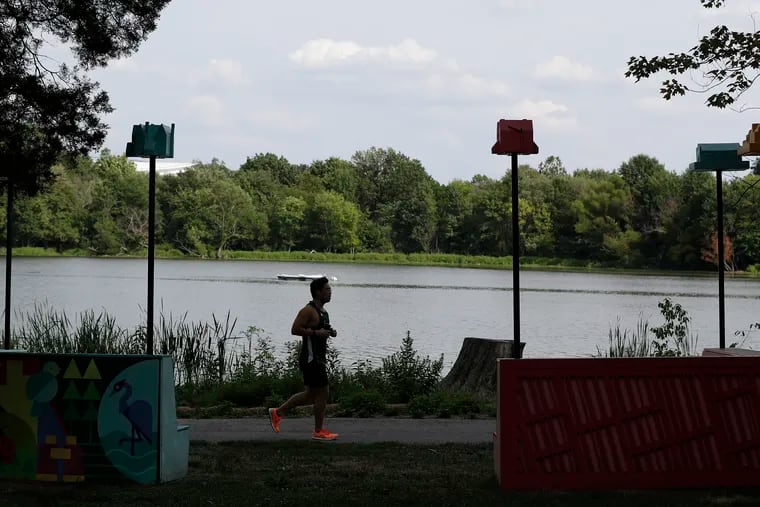 A runner along Edgewood Lake with a birdhouse in view at FDR Park in August 2022.