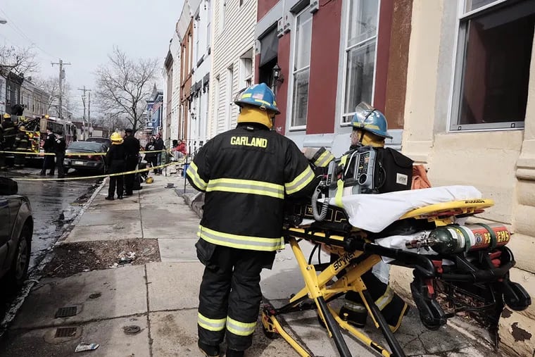 Fire fighters and paramedics at the scene of a fire in the 2400 block of W. Norris St., in North Philadelphia where two firefighters were injured when a ladder  came in contact with electric lines on Mar. 16, 2015. (Ed Hille / Staff Photographer )