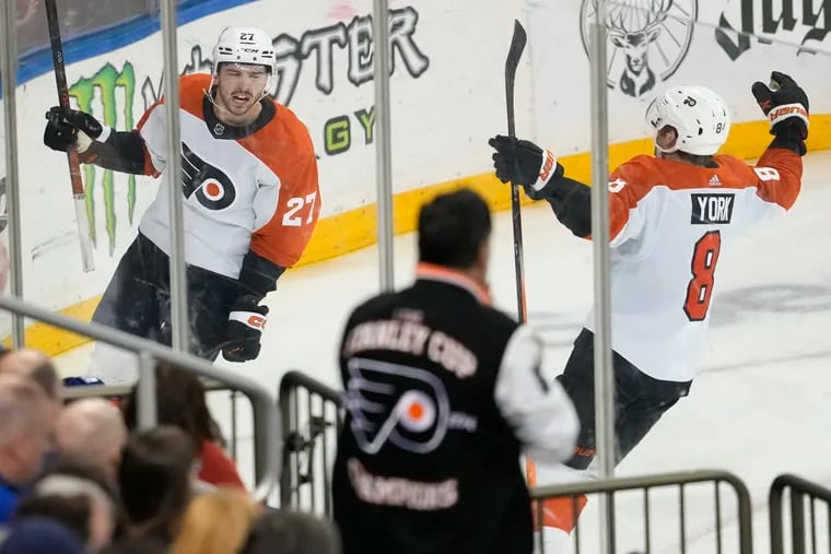Noah Cates (left) and Cam York (right) celebrate after Cates scored the Flyers' fourth goal against the New York Rangers.