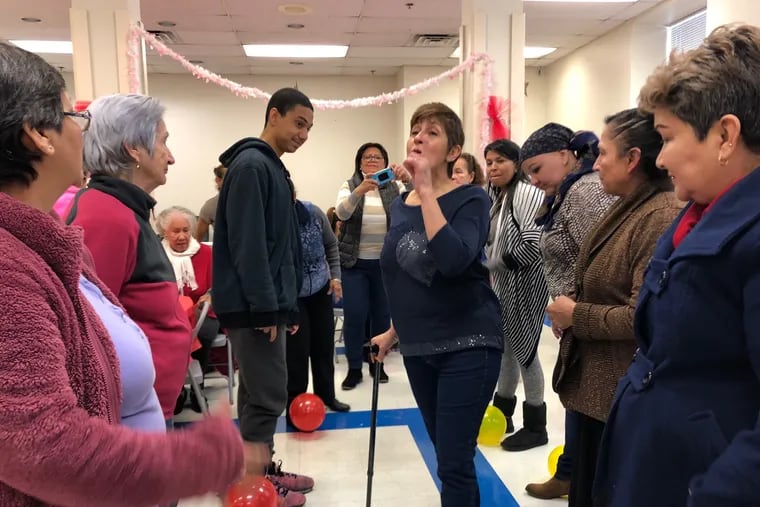 Marla Vega (center) leads games at Grupo Morivivi's Valentine's Day celebration. She has been co-coordinating the cancer support group for Latino and Hispanic people since 2014.