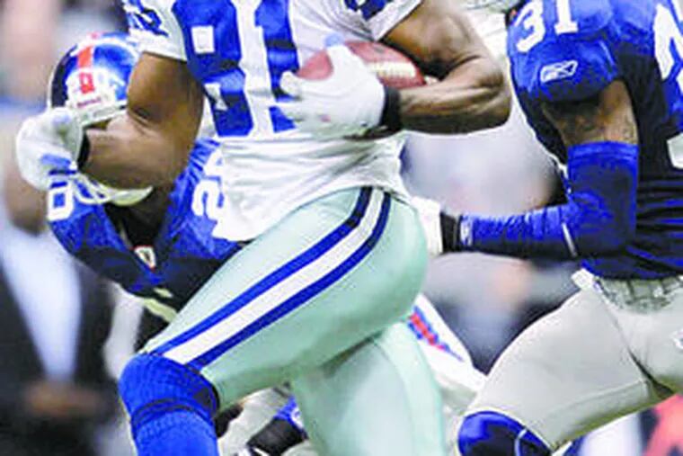 The Cowboys&#0039; Terrell Owens (81) picks up 25 yards on a pass play as the Giants&#0039; Aaron Ross (31) moves in for the tackle.