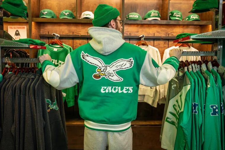 Matthew Brenner, assistant manager at Mitchell & Ness, models the jacket he purchased for himself on the day the shop dropped the iconic kelly green Eagles jacket, on Nov. 9, 2023. Staff members were permitted to buy one jacket, customers were allowed two jackets per customer.
