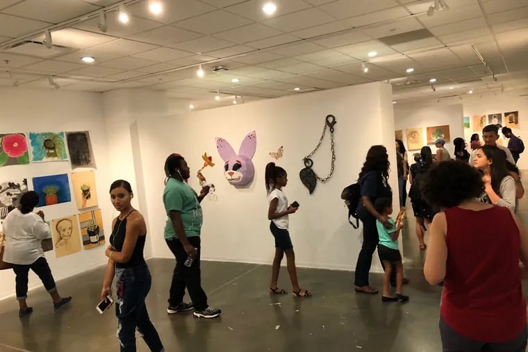 Friends and relatives of students from the Tyler School of Art summer programs stroll through the gallery at which the students' work was displayed Friday.