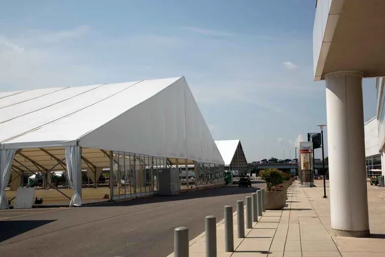 The media tents await the Democratic convention outside the Wells Fargo Center. Inside the center, the transformation has been sweeping, and sports memorabilia has been relocated or covered up.