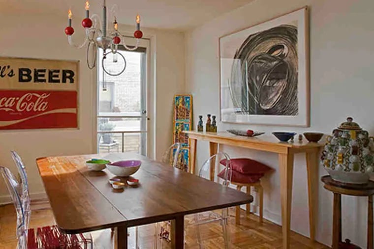 The dining room of Fiammenghi's home near the Art Museum features a charcoal by local artist Carol Moore and a sign salvaged from a Fairmount Avenue beverage store. (Akira Suwa / Staff Photographer)