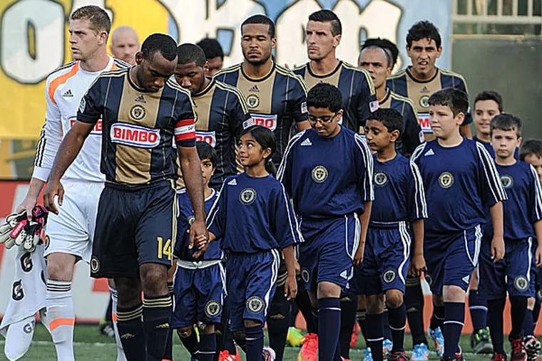 Union defender/midfielder Amobi Okugo and teammates escort young fans onto the field. (John Geliebter/USA TODAY)