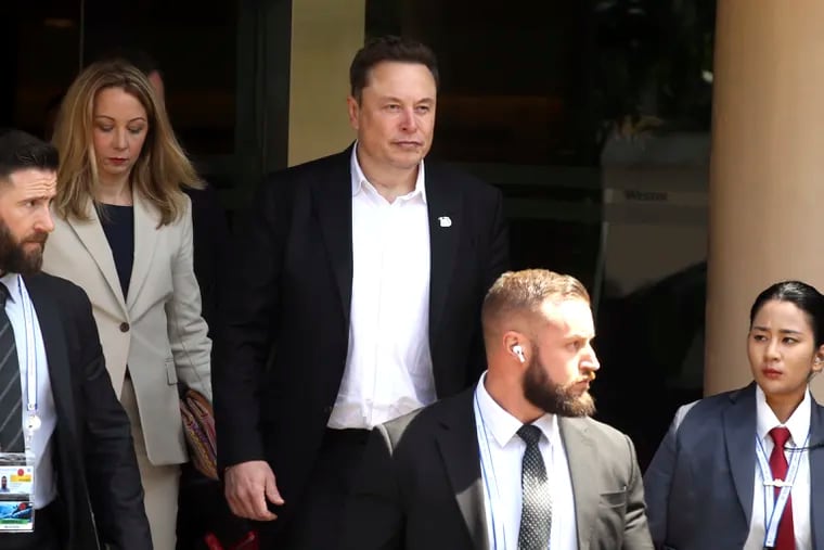 Elon Musk (center) arrives for the 10th World Water Forum in Nusa Dua, Bali, Indonesia, on May 20. A group of Tesla shareholders are asking investors to vote against a compensation package worth more than $50 billion for CEO Elon Musk, saying that it's not in the electric vehicle maker's best interest.