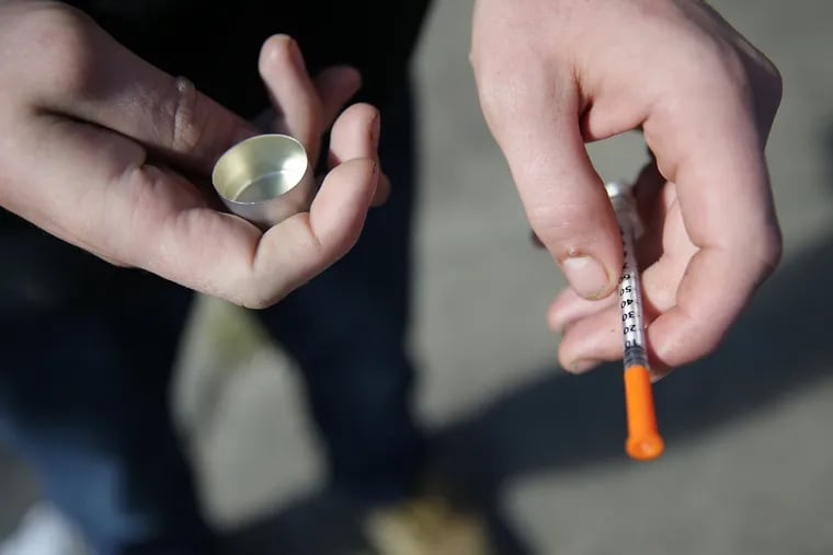 A fentanyl user who didn't want to be identified holds a needle near Kensington and Cambria Streets.
