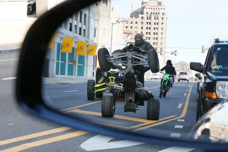 Quads and dirt bikes pop wheelies on Broad Street as they head south racing past stopped traffic in front of Temple Hospital in Philadelphia on March 15, 2020.