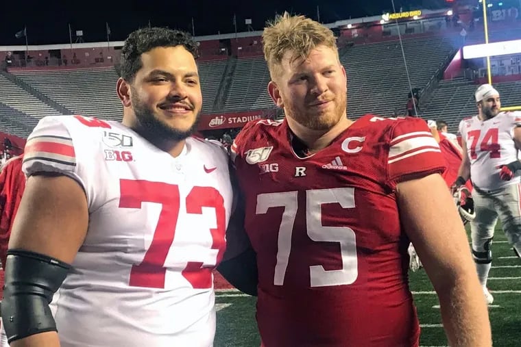 In this photo taken Nov. 16, 2019, Ohio State's Jonah Jackson (73) stands with Rutgers' Zach Venesky (75) after an NCAA college football game in Piscataway, N.J. The game was a homecoming of sorts for Jackson, and Scarlet Knights captain Venesky was enjoying the get-together. Jackson is one of his best friends and a major reason Venesky is a captain this year. (AP Photo/Matt Sugam)
