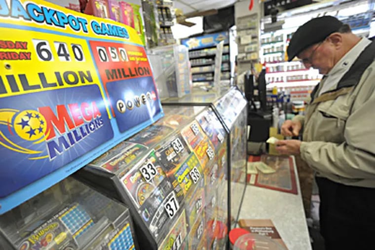 A player checks his Mega Millions ticket at Towne Market in Phillipsburg, N.J. The jackpot for Friday's drawing was up to $640 million Friday afternoon, or $462 million for the cash up front. MATT SMITH / The Express-Times