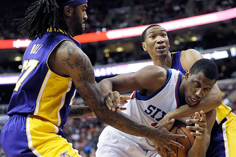 The Lakers' Jordan Hill, left, and Wesley Johnson, right, trap Philadelphia 76ers' Thaddeus Young (21) during the second half of an NBA basketball game on Friday, Feb. 7, 2014, in Philadelphia. The Lakers beat the 76ers 112-98. (Michael Perez/AP)