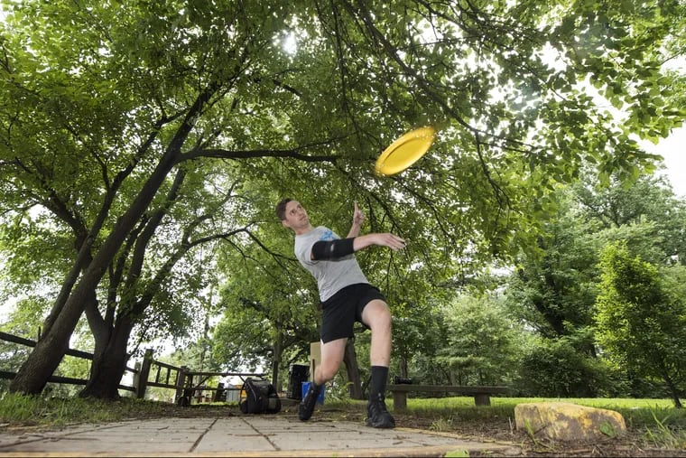 Alex Caldwell, throws a flying disc at the Sedgley Woods' 27-hole disc golf course in East Fairmount Park.