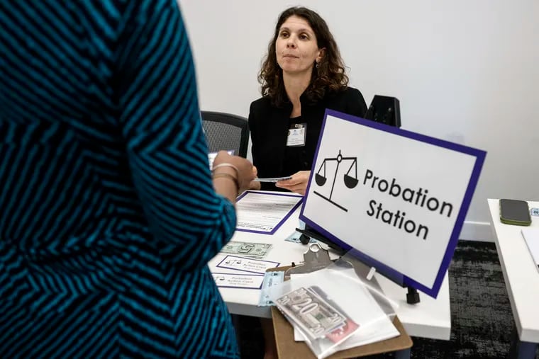 Maya Sosnov, a law clerk for Judge Theodore McKee, works the probation station at a reentry simulation event hosted by the Philadelphia Bar Foundation. Participants were given a wallet with a new identity in it, replicating the challenges a person coming home after being incarcerated might face.