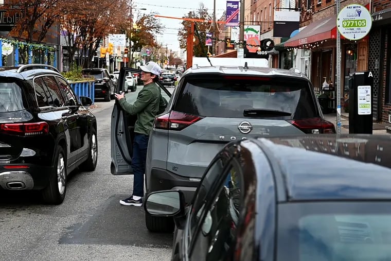 Blaise Leuzzi parks his car along the metered spaces along the Passyunk Shopping District on Sunday. "People should be able to enjoy the city with their family in town and not worry about the parking," he said.