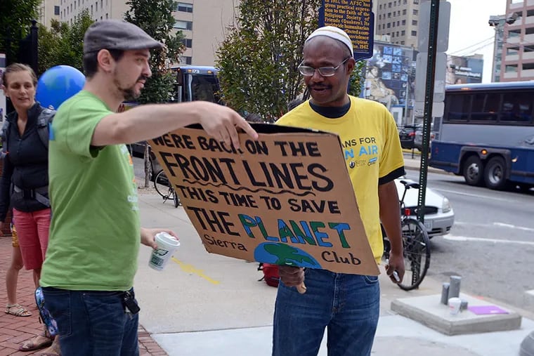 Bus commander Jonathan Lipman (left) helps other environmentalists including Gary Lythe (right) with the Sierra Club's "Veterans for Clean Air," board buses outside the Friends Center at 15th & Arch early Sunday morning, heading to New York City for the People's Climate March.