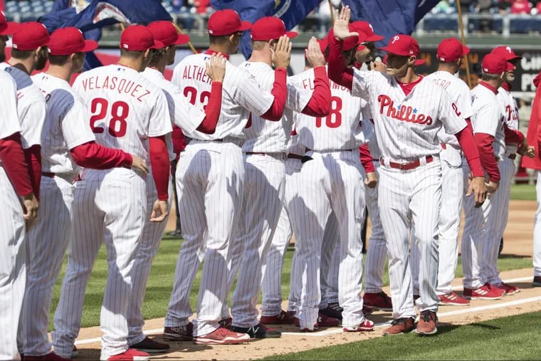 Phillies manager Gabe Kapler (right) gets high fives from his team as he is introduced before the game.