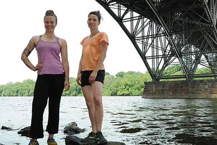 Alie Vidich (right), 29, of West Philadelphia, producer and choreographer of the &quot;Invisible River&quot; performance on the Schuylkill, and Amy Lynne Barr, 35, of Port Richmond, dance collaborator, stand in the river underneath the Strawberry Mansion Bridge.