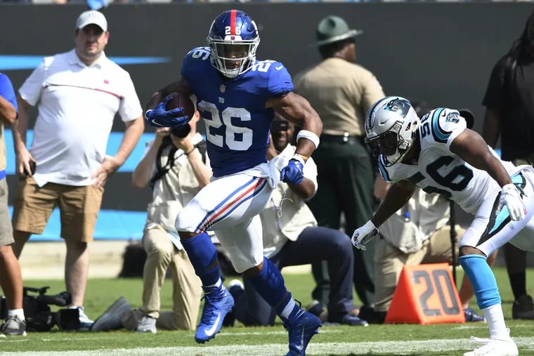 New York Giants running back Saquon Barkley (26) races past Carolina Panthers linebacker Jermaine Carter (56) on his way to the end zone and a touchdown during the first half at Bank of America Stadium Sunday, Oct. 7, 2018. The Giants won, 33-31. (David T. Foster III/Charlotte Observer/TNS)