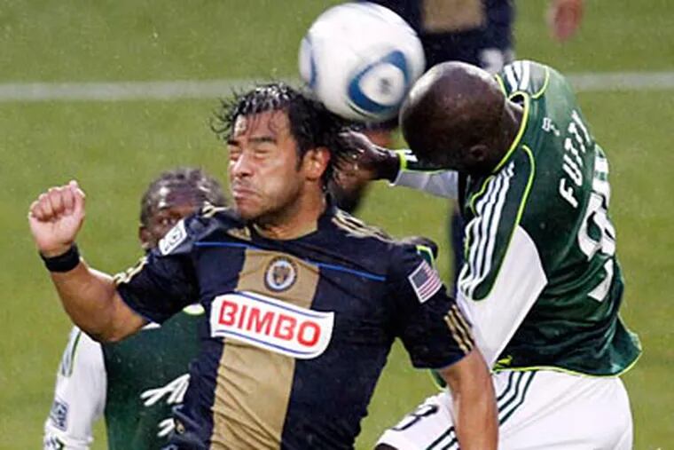 Union forward Carlos Ruis and Timbers defender Mamadou Danso vie for a header during the first half. (Don Ryan/AP)