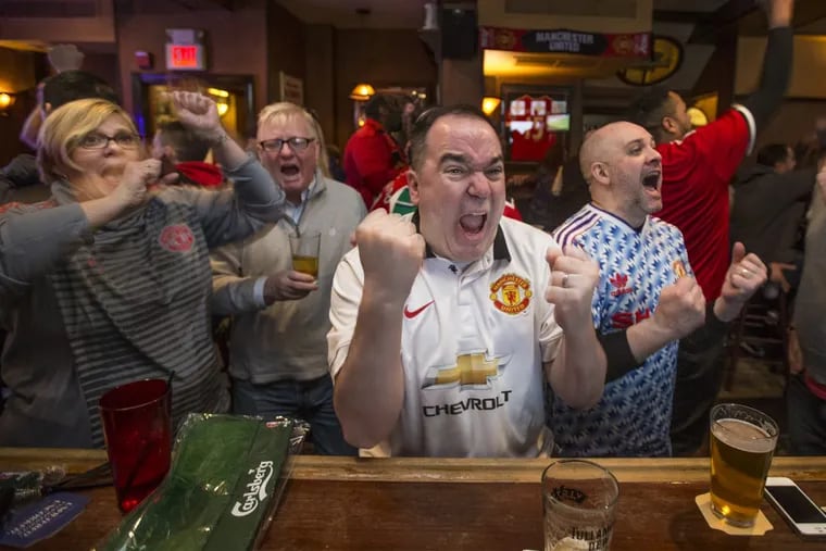 At the Black Sheep, Tom Hoffman, center, from Port Richmond, and Laura Lapaugh, left, of Westampton, N.J., celebrate a Manchester United goal against Chelsea on Sunday morning, February 25, 2018.
