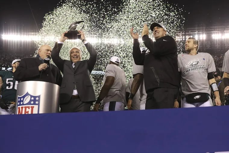 Jeffery Lurie and Doug Pederson stand triumphant  with the NFC championship trophy after the Eagles beat the Minnesota Vikings on Jan.  21, 2018, at Lincoln Financial Field.