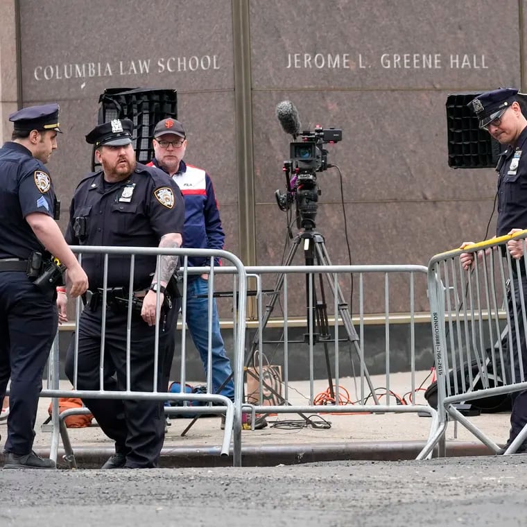 New York City Police officers set up barricades around gathered members of the press outside the Columbia University campus.