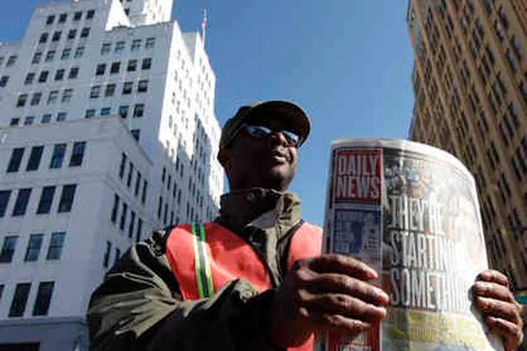 Dave Sexton sells the Daily News outside the newspaper building in Philadelphia on Wednesday during the auction.