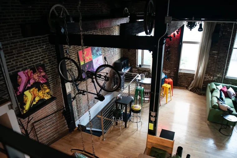 A bike hangs from a pulley system at the entrance of Butch Cordora’s loft apartment in Callowhill, Philadelphia on Friday, Oct. 13, 2023. Cordora, who is new to the neighborhood, began living in the apartment in September 2023.