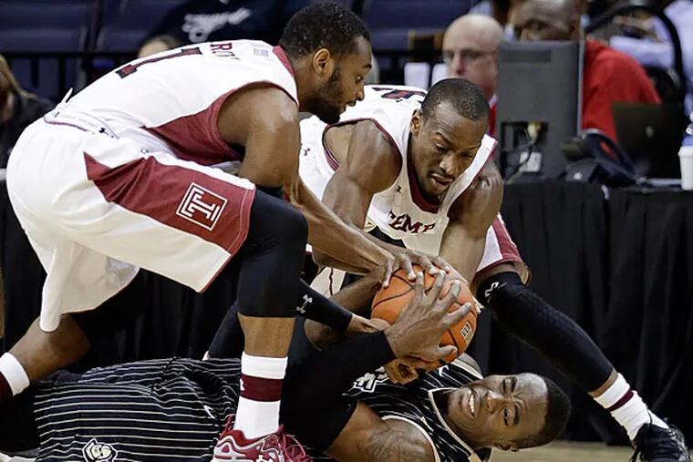 Central Florida guard Isaiah Sykes, bottom battles with Temple's Josh Brown (1) and Will Cummings, top right, for the ball in the first half of an NCAA college basketball game at the American Athletic Conference men's tournament Wednesday, March 12, 2014, in Memphis, Tenn. (Mark Humphrey/AP)