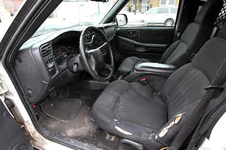 The interior of a school police officer's car. The same car also has a mangled bumper and a check-engine light on. (Lawrence Kesterson / Staff)