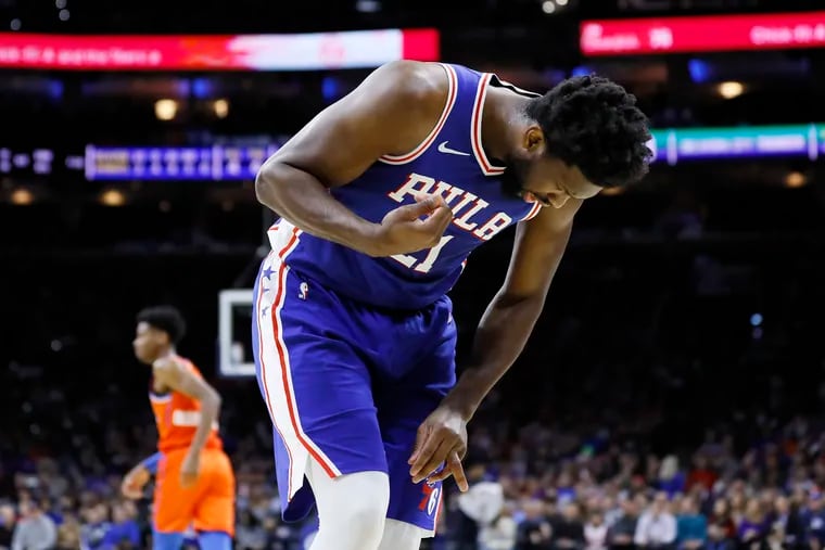 Philadelphia 76ers' Joel Embiid looks at his injured finger during the first half of an NBA basketball game against the Oklahoma City Thunder, Monday, Jan. 6, 2020, in Philadelphia.