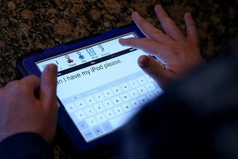 Stefan Velocci, 21, who has autism and is nonverbal, asks his mom for his iPod using an iPad with the Proloquo2Go alternative communication app at his home in Newtown earlier this month.