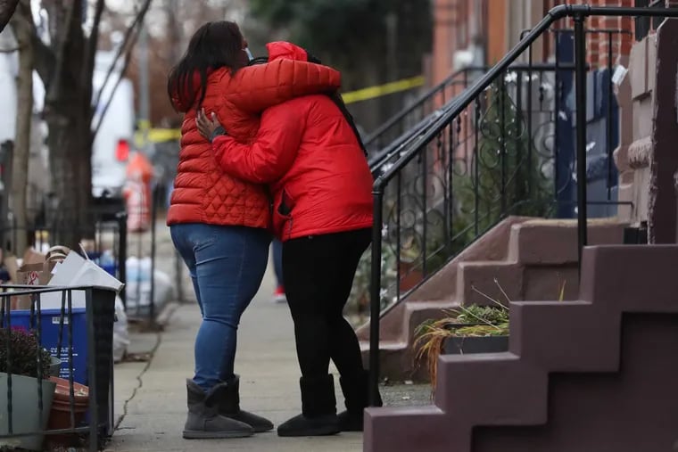 Two people embrace a block away from the scene of a fatal fire in the Fairmount section of Philadelphia on Wednesday.