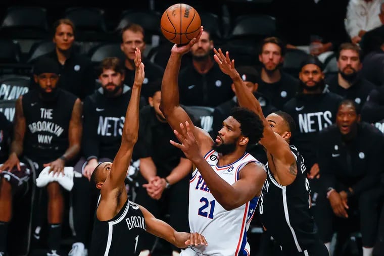 Sixers center Joel Embiid shoots against Brooklyn Nets forward Mikal Bridges and center Nic Claxton during Game 3 of the first round.